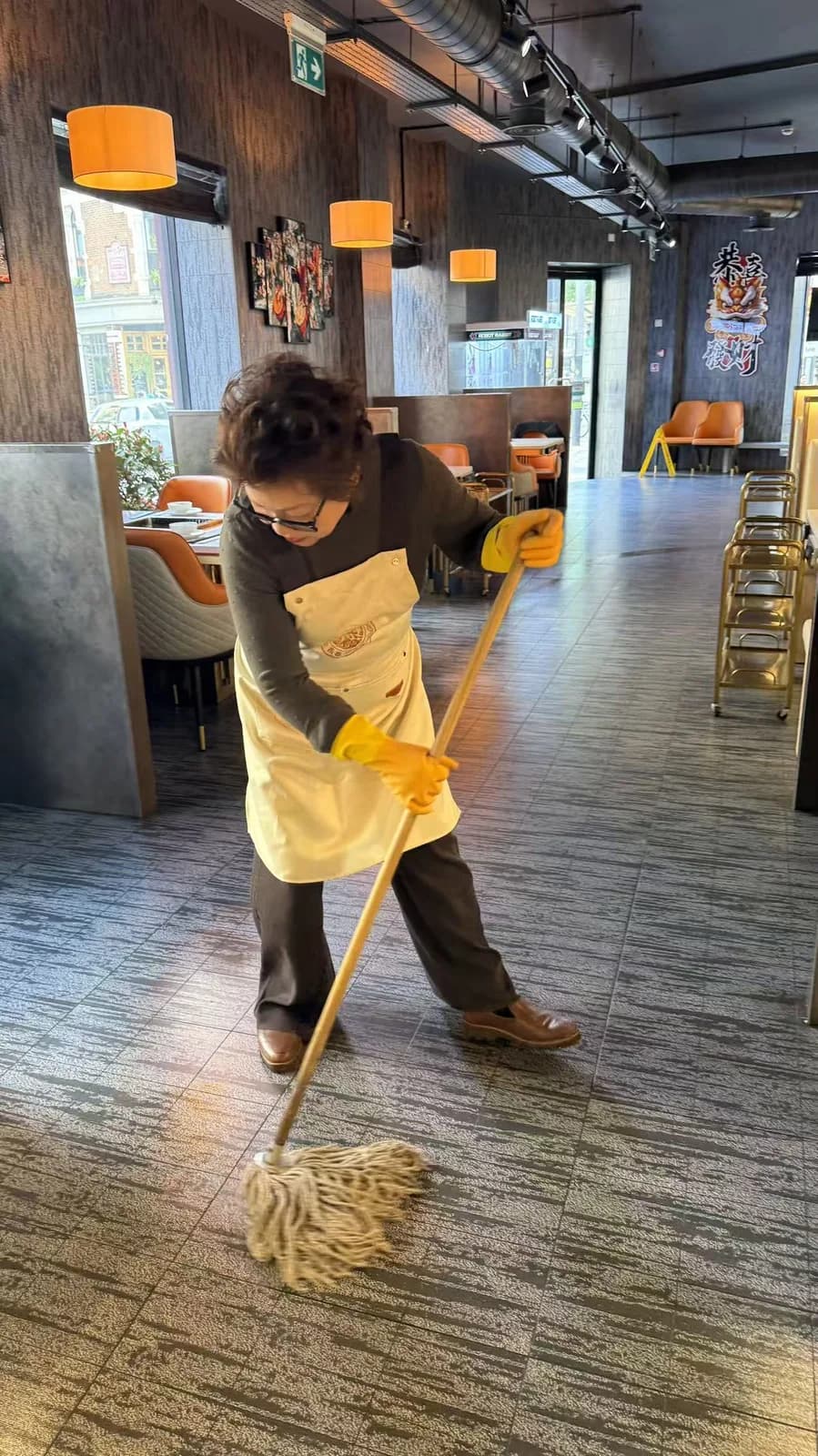 Ping Jie mopping the dining room before opening